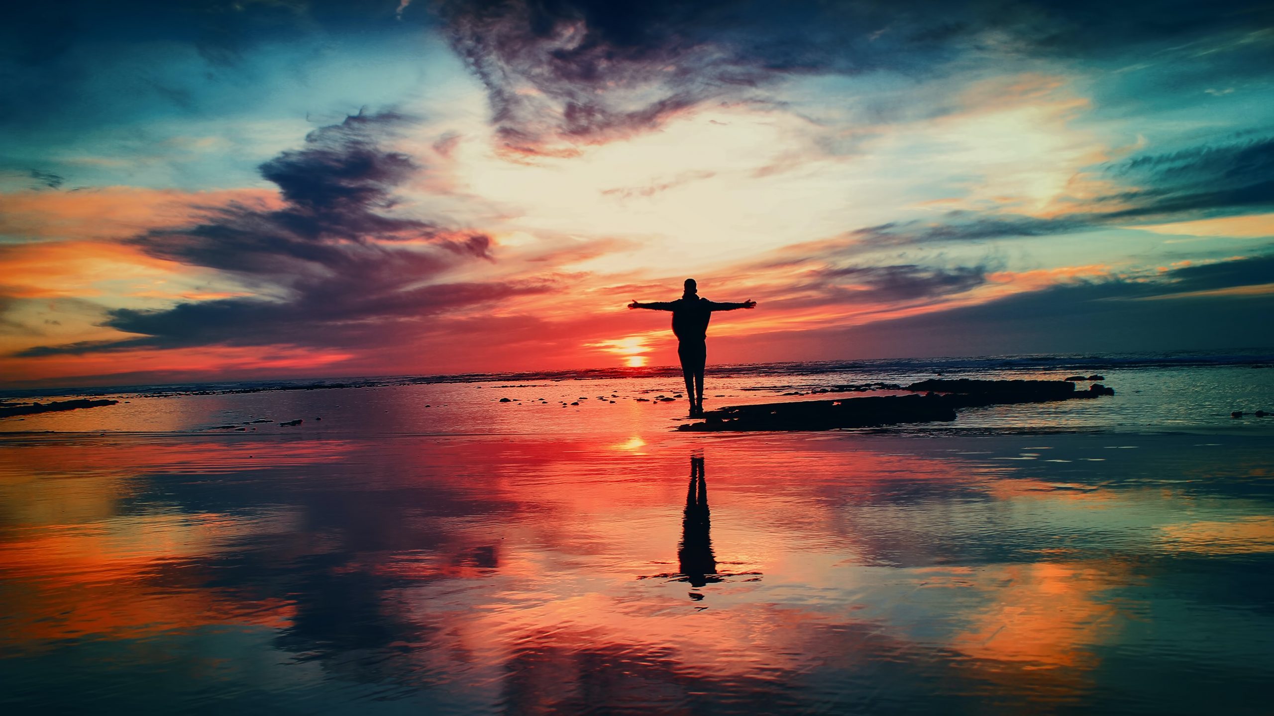 Man Standing near Water at Sunset